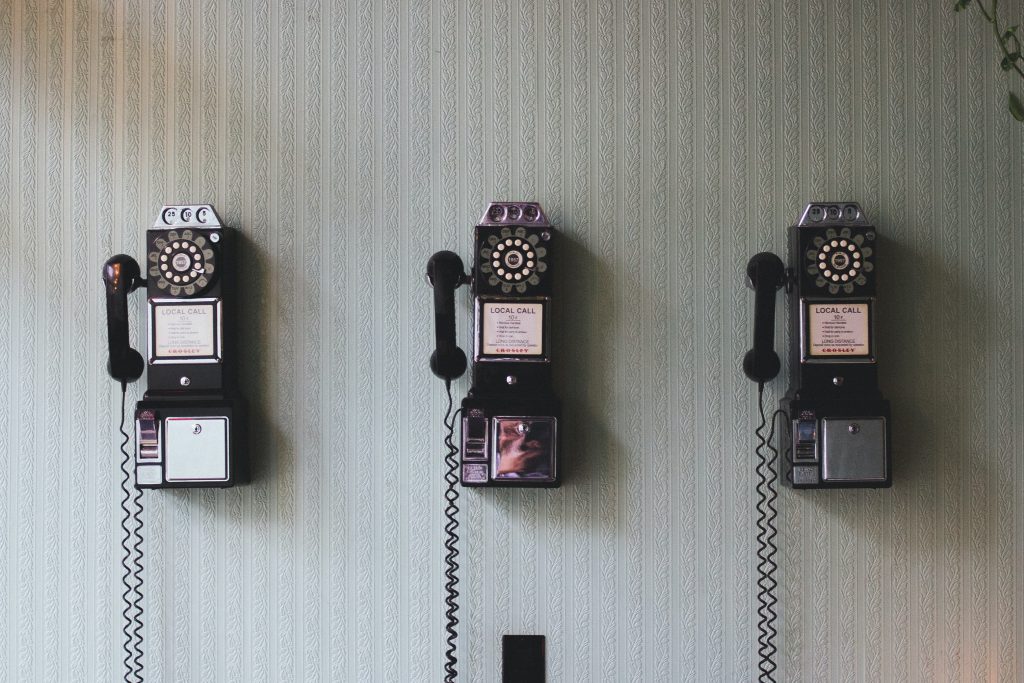 Row of old rotary telephones holding on a wall